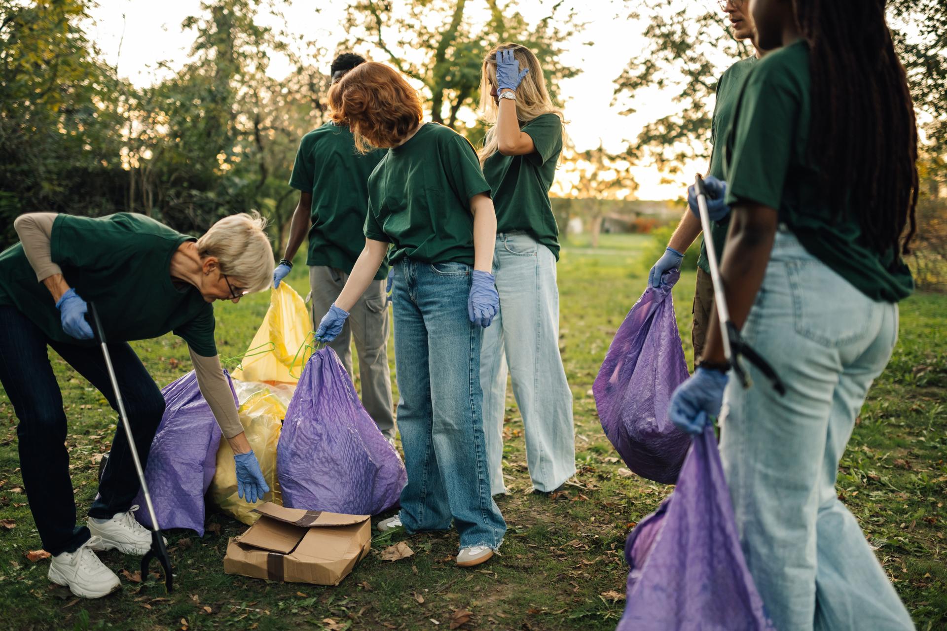 Group of people volunteers collecting rubbish in park