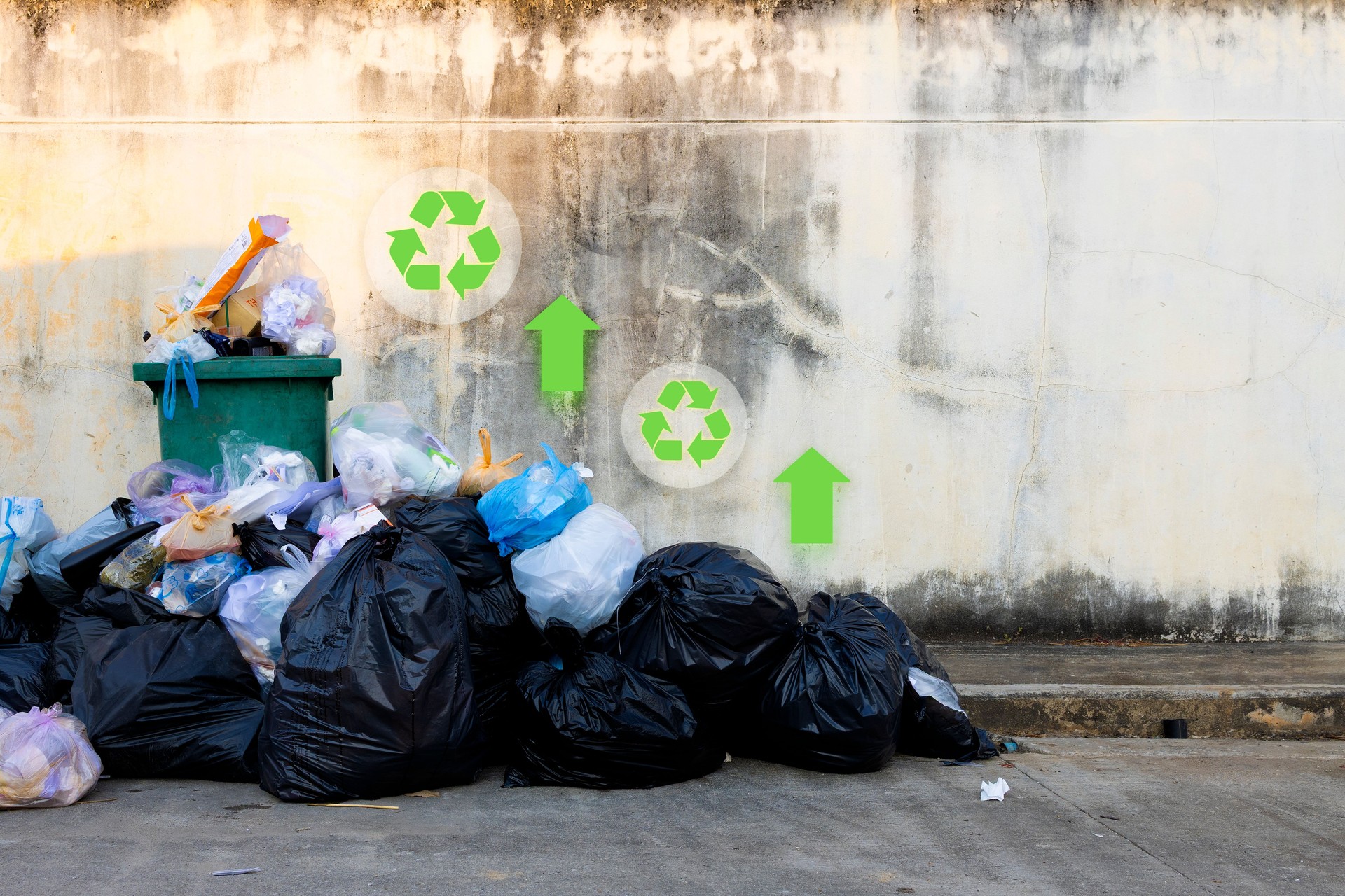 Overflowing Garbage with Recycling Concept on Dirty Urban Wall